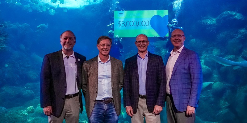 From left to right: Ken Hagan, Darryl Shaw, Bruce Bodine, Roger German in front of a check for $3 Million held by divers in the habitat behind them