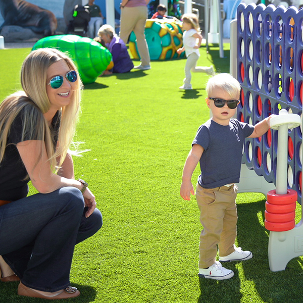 little boy with mom outside with big connect four at The Florida Aquarium