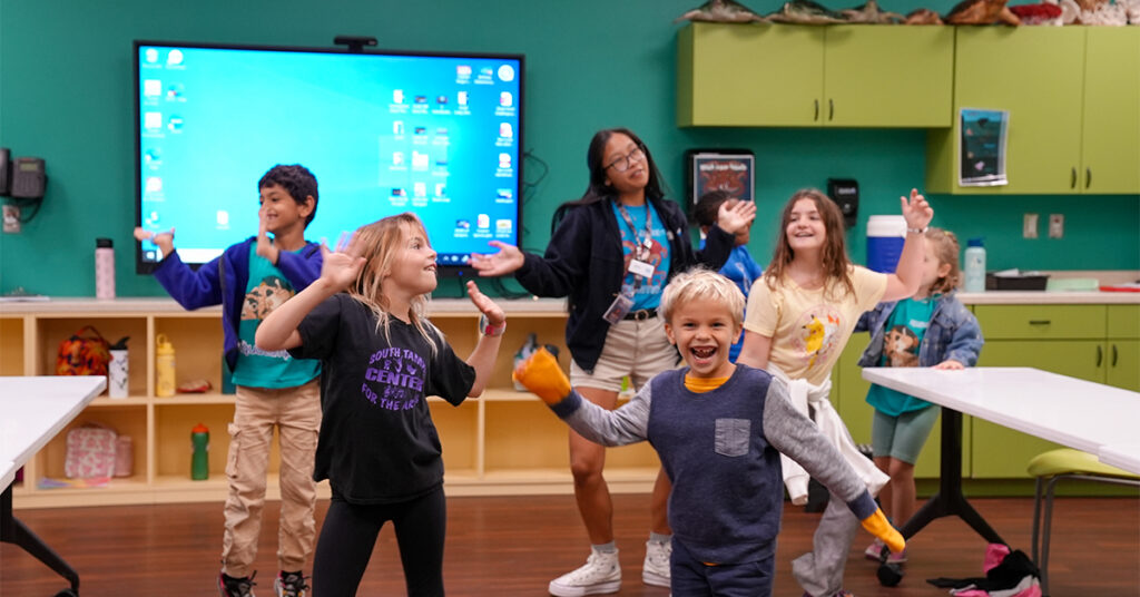 group of kids dancing with a camp staffer at The Florida Aquarium