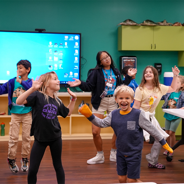 group of kids dancing with a camp staffer at The Florida Aquarium